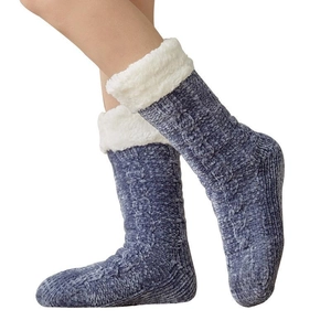 Blue knit thermal winter floor socks with white faux fur lining worn by a model