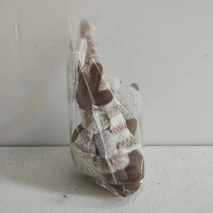 Detail of plush reindeer Christmas ornament with knitted hat in clear plastic packaging