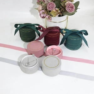 Elegant round velvet jewelry boxes with ribbon bows for rings and necklaces