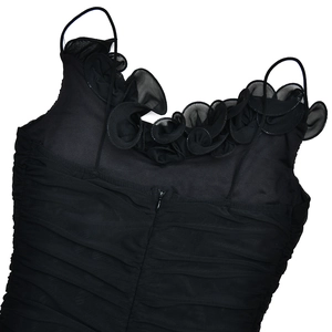 Détail de la robe noire à fines bretelles avec volants en mesh et fermeture éclair