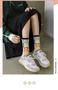 Detail of colorful smiley floral checkerboard socks paired with retro suede sneakers