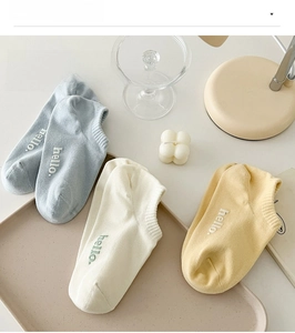Detailed view of three pairs of pastel cotton ankle socks with letter embroidery