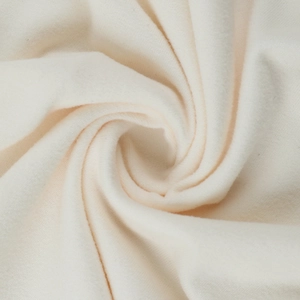 Gros plan sur la texture du tricot blanc cassé avec des drapés doux et des plis