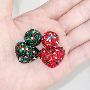 Detailed macro view of colorful rhinestone-encrusted round and heart-shaped beads on palm