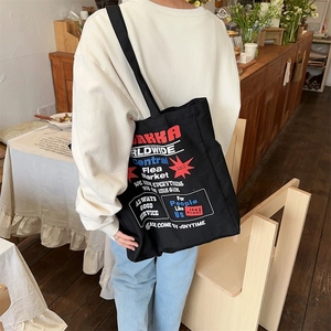 Close-up of black canvas tote bag featuring retro American style AKKA print details