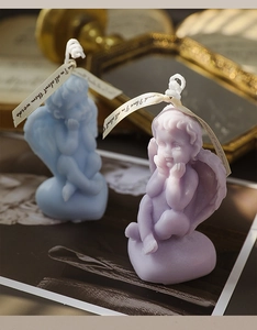 Detail of blue and purple angel scented candles with heart bases and elegant ribbons