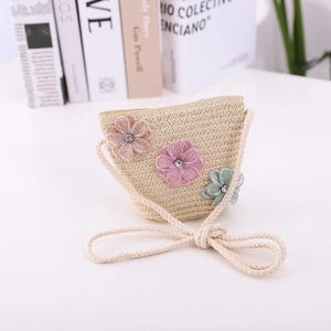 Detail of a straw crossbody bag for kids with 3D mesh flowers and woven shoulder strap