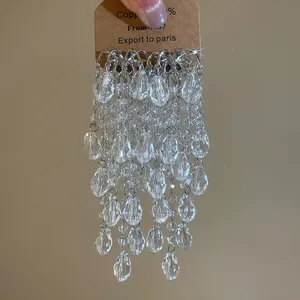 Detailed view of luxury silver tassel earrings with tiered water-drop crystal dangles