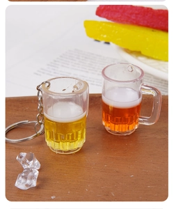 Détail de mini porte-clés de chope de bière avec mousse sur une table en bois rustique