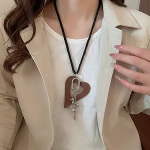 Leather heart and silver horse pendant long necklace for women over beige blazer