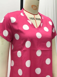 Detail of V-neckline and white polka dot pattern on rose red short sleeve dress