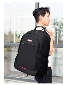 Side view of black business backpack on model featuring reinforced handle and mesh pocket