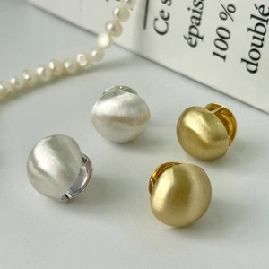 Detail of matte brushed S925 silver and gold ball earrings with pearl necklace