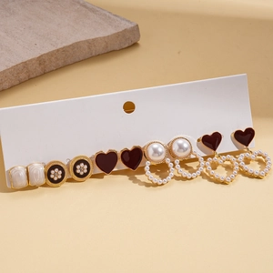 Elegant 10-piece set of gold-tone pearl and enamel earrings on a display card