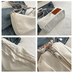 Detail view of large white nylon crossbody bag with colorful geometric pattern shoulder strap