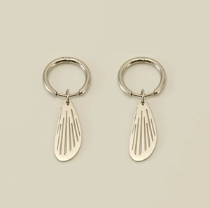 Detailed close-up of silver hollow wing pendant earrings with fine vein textures