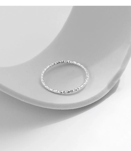 Macro shot of silver S925 sterling ring featuring textured diamond-cut surface finish