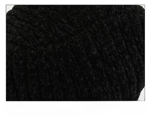 Detail of multi-panel stitching on the crown of a black chenille knit winter beanie