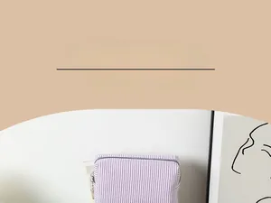 Detailaufnahme der Kosmetiktasche mit lila-weißen Seersucker-Streifen und Reißverschluss