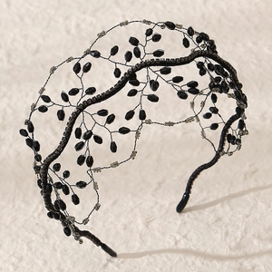 Elegant black beaded headband with intricate faceted crystal branches on a metal frame