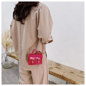 Detail of rose red mini jelly crossbody bag with glossy PVC finish and gold chain