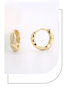 Close-up of twisted rope texture and pavé zircon stones on gold-plated hoop earrings