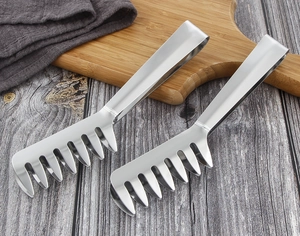 Close-up of stainless steel meat shredder claws on a wooden cutting board