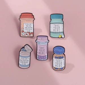 Vue macro détaillée de pin's colorés en émail en forme de flacon avec citations mignonnes