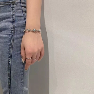 Silver thorn bracelet with moonstone accent and minimalist rings worn by a model