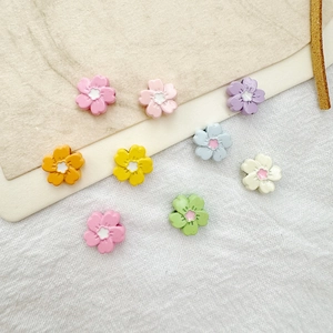 Close-up of colorful resin flower beads for DIY jewelry making in various vibrant summer colors