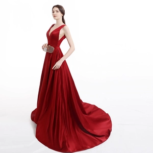 Elegant wine red satin evening gown with deep V-neck and luxurious floor-length train
