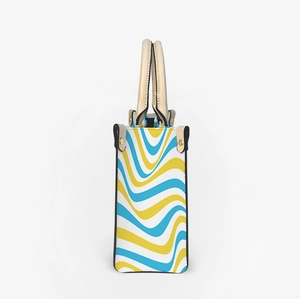 Side view of tote bag featuring blue and yellow wave patterns with golden metal rivets