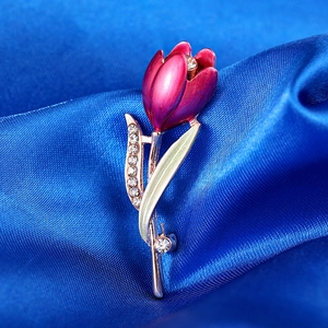 Macro view of purple tulip brooch with sparkling rhinestones on blue satin fabric