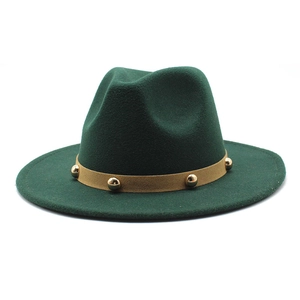 Detail of dark green wool fedora hat featuring khaki leather band with gold rivets