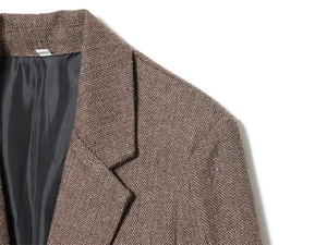 Detailed view of the brown herringbone wool blazer collar and textured shoulder seams