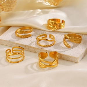 Set of six gold geometric open rings featuring snake and feather designs on white stone