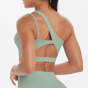 Detail of asymmetrical back straps on bean green sports bra with hollow out design