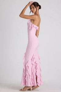 Détail d'une robe longue rose moulante avec des volants élégants et un design dos nu licou