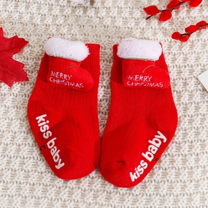 Detail view of red Christmas baby socks with non-slip grips and festive knit patterns