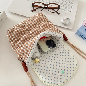 Detail of checkered quilted puffer bag with polka dot lining and spacious interior