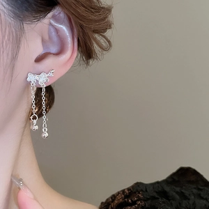 Close-up of a silver flower tassel earring with pavé stones and tiny bell details