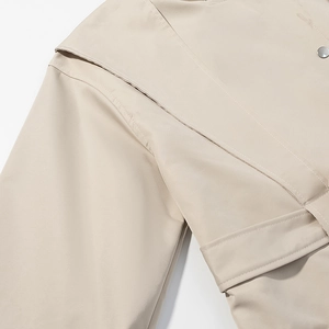Detail shot of beige windbreaker fabric texture and round silver button stitching