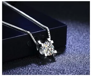 Macro view of a single sparkling zircon pendant with four-claw setting on silver box chain