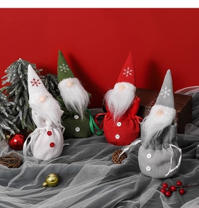 Detail of four knitted Christmas gnome candy bags with snowflake embroidery and drawstring