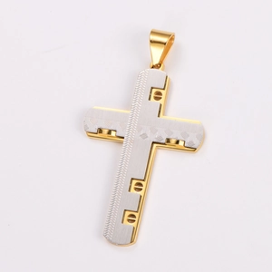 Macro shot of two-tone gold and silver cross pendant with intricate textured patterns