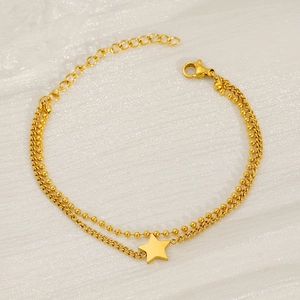 Detail of double-layer gold stainless steel chain bracelet with star charm pendant
