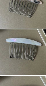 Close-up of a white shell luster acetate hair comb with durable metal teeth for styling