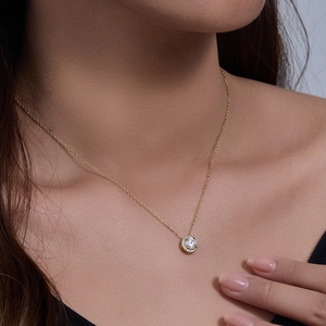 Close-up of a delicate S925 silver gold-plated necklace with a sparkling round zircon pendant
