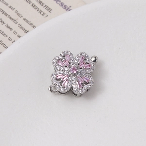 Macro detail of rotating silver flower clasp with pink zircon stones and pave crystals
