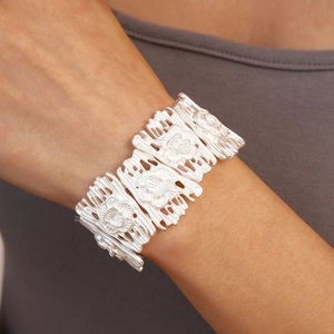 Detailed relief of vintage silver floral patterns on wide matte metal cuff bracelet